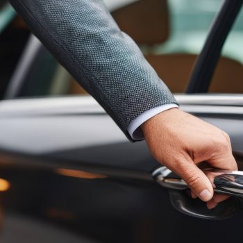 Professional chauffeur opening the door of a luxury vehicle for a businessman, highlighting Eurotaxis' executive transport service with reliable, comfortable, and professional travel for corporate clients.