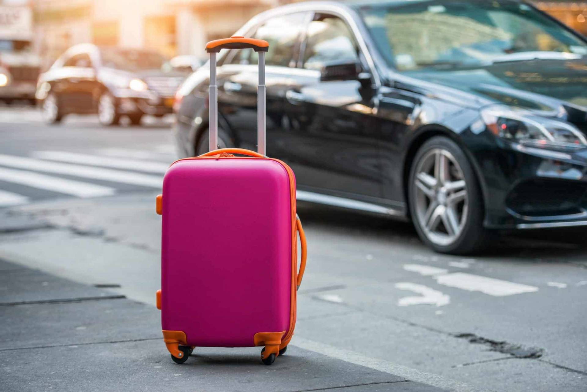 Pink Suitcase next to Black Taxi